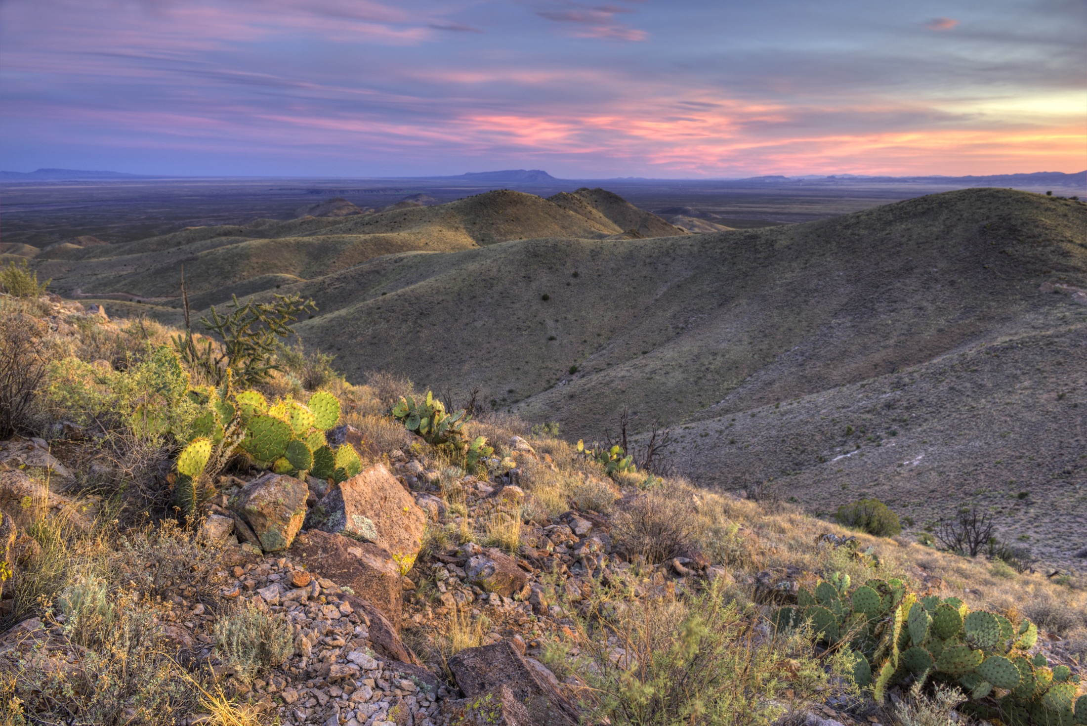 A colorful sunset over arid ranch land